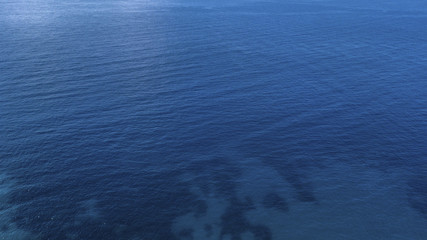  Aerial view of the blue waters of the Mediterranean Sea and specifically of the Tyrrhenian Sea. Sunlight is reflected on the surface of the water.