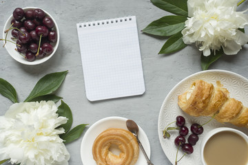 Frame custard cakes cherry flowers peony notepad tea Cup. Copy space Flatlay