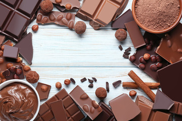 Chocolate pieces with nuts and cocoa balls on wooden table