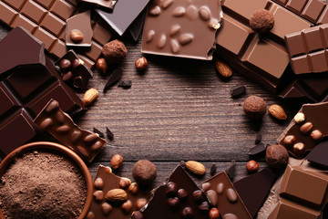 Chocolate pieces with cocoa powder in bowl on wooden table