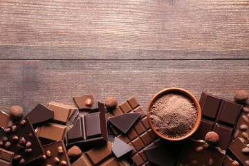 Chocoladestukjes met cacaopoeder in kom op houten tafel