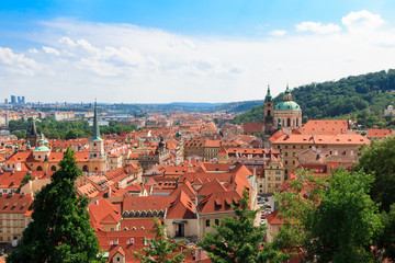 Obraz premium Beautiful and ancient city of Europe - Prague, Czech Republic. View of the city from the observation deck. Small houses and the river Vltava. Charles Bridge and temples.