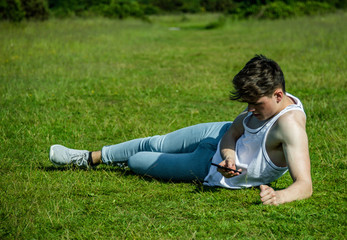 A young adult male sitting outside on a summer's day