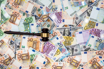 hammer of the judge on background of dollar and euro bills