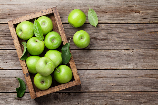 Green apples in wooden box