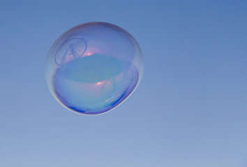 Ferris wheel reflected on a soap bubble