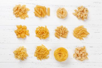 Various pasta on white wooden table