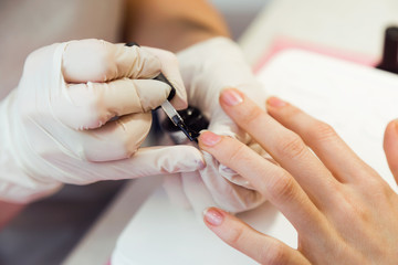 Young woman doing manicure in salon. Beauty concept.