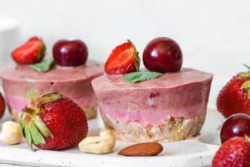 raw strawberry and cherry cheesecake with fresh berries, mint, nuts. healthy vegan food