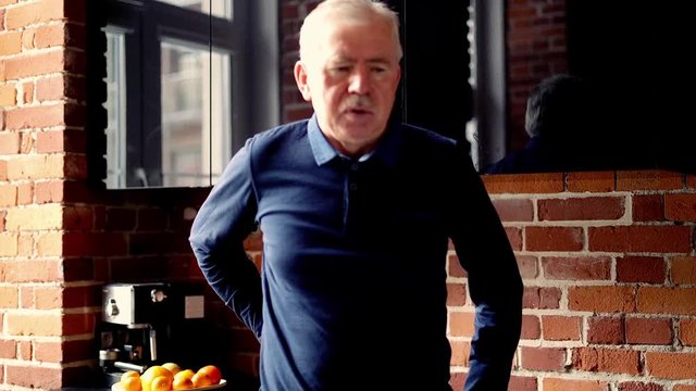 mature man having backbone pain at home.
