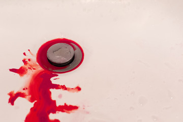 Bleeding blood on white floor of sink in bathroom, hemophobia concept
