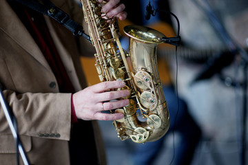 Obraz premium The hands of a professional musician, playing the saxophone on stage