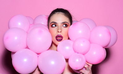 Fototapeta na wymiar cheerful pretty woman with balloons in pink studio.