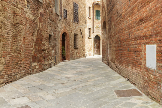 Fototapeta traditional alleyway with red bricks houses in Itally