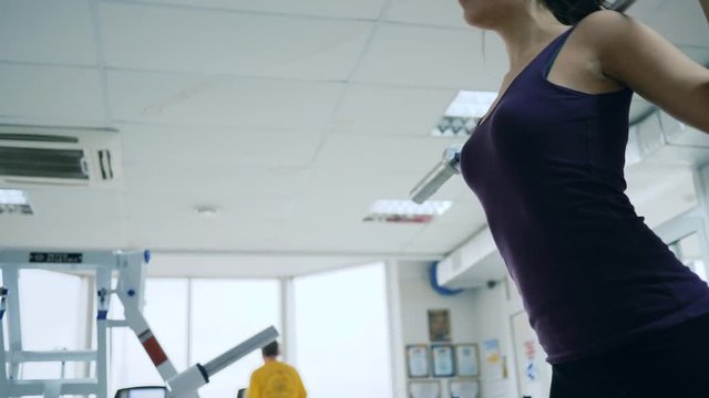 gym, attractive girl with barbell on shoulders does sports exercises indoors