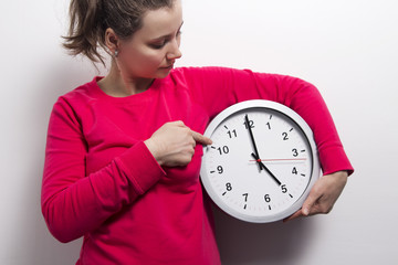 Young woman with clock. Watching time concept.
