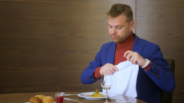 Businessman taking white napkin before eating during lunch in gourmet restaurant