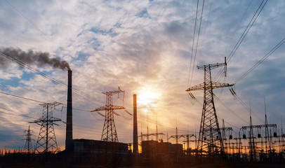 Fototapeta premium distribution electric substation with power lines and transformers, at sunset