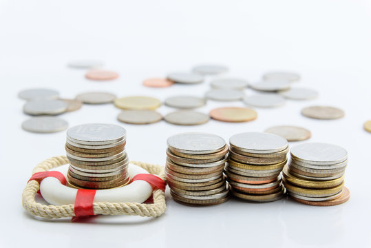Money saving and financial wealth protection concept : Stack of coins in a red lifebuoy on white background. Securing large value of money by applying an insurance, insured assets safe & secure future