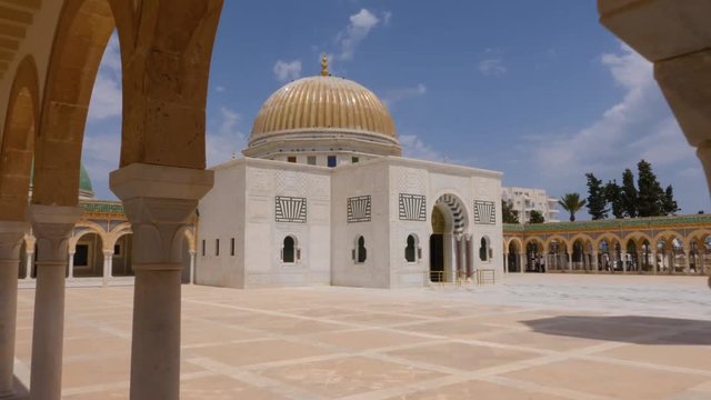 Central part mausoleum Habib Bourguiba topped by large golden dome in Monastir. Track out parallax effect