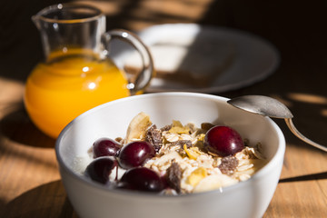 Bowl of yogurt with muesli and fruits, cream cheese and orange juice.