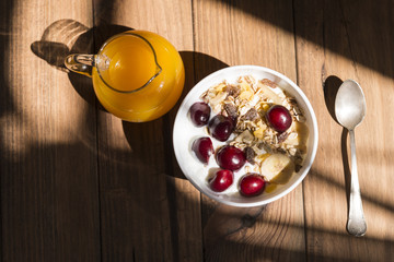 Bowl of yogurt with muesli, fruits and orange juice.
