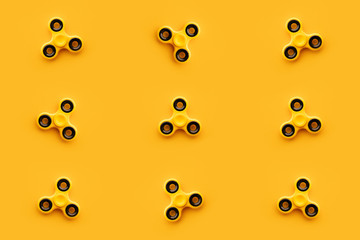 Seamless pattern background of yellow fidget spinner toy