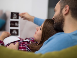 Obraz na płótnie Canvas pregnant couple looking baby's ultrasound