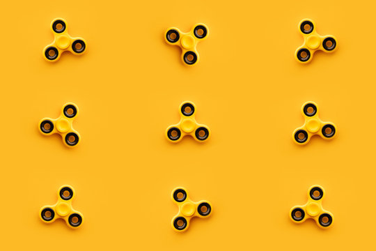Seamless pattern background of yellow fidget spinner toy