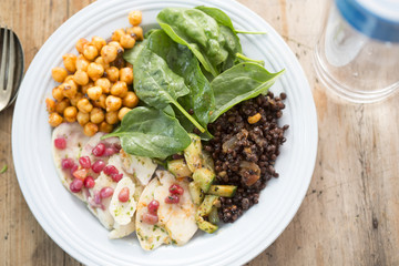 Persian salad with beluga lentils in red onion chutney, cucumber, tomato, onion, chickpeas, baby leaf spinach and pomegranate seeds. 