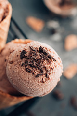 Homemade chocolate ice cream in waffle cones and pieces of dark chocolate.Toned image.