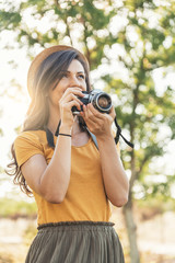 Smiling young woman using a camera to take photo.