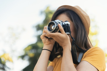 Young woman using a camera to take photo.