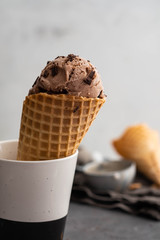 Homemade chocolate ice cream in waffle cones and pieces of dark chocolate 