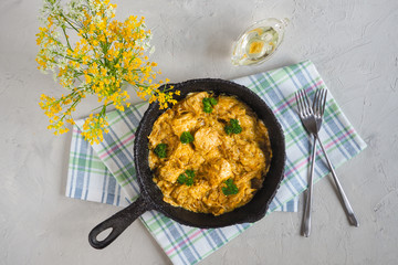 Spicy chicken in a sauce of coconut milk close-up in a frying pan. 