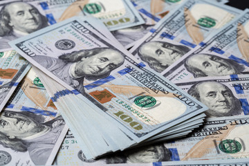 Cash of hundred dollar bills, dollar background.