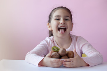 Cute little girl eating fresh kiwi fruits