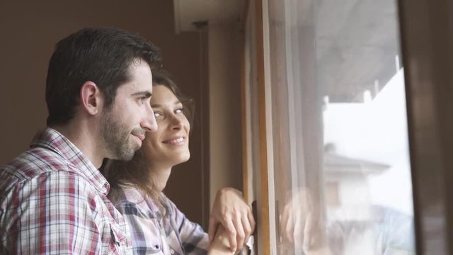 Couple enjoying the view from the window in their new house