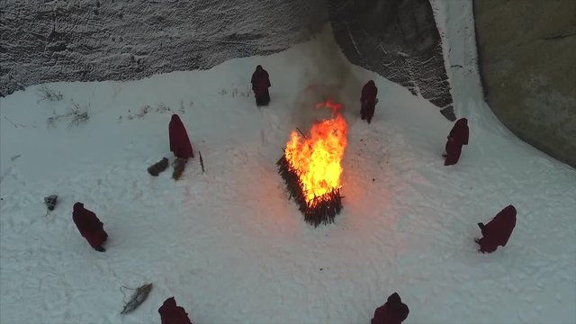 group of monks near the fire in the mountains at dusk, top view. Footage