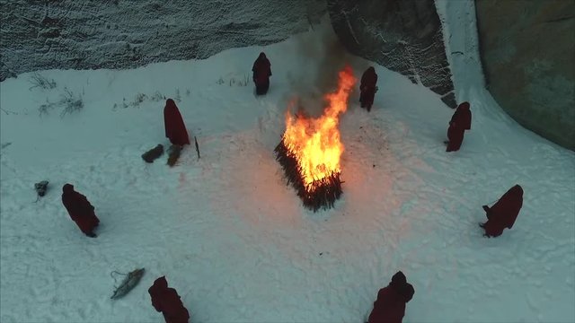 group of monks near the fire in the mountains at dusk, top view. Footage