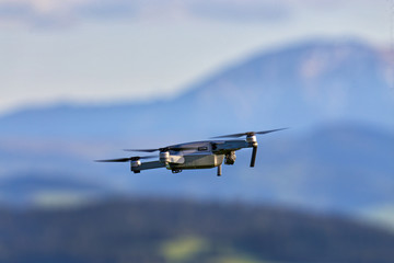 Fototapeta na wymiar Drone with camera flying over mountain fields. Aerial photography and videography