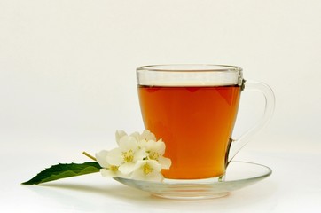 A сup of fragrant tea with aromatic jasmine flowers.