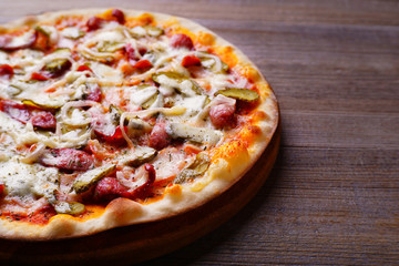 Delicious napoli pizza with salami and gherkins on wood, close up. Italian food, restaurant menu photo
