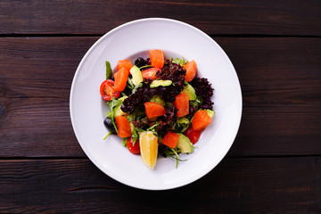 Smoked salmon seafood salad with lettuce and cherry tomatoes. Restaurant seafood menu photo, property nutrition and healthy food concept 