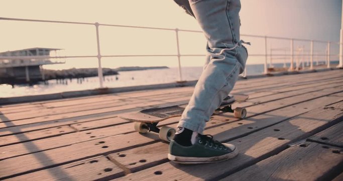 Young hipster man longboarding on urban jetty