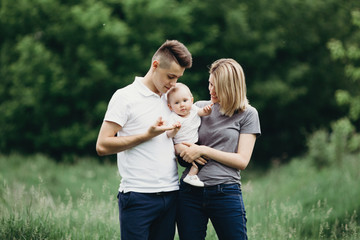 Parents and daughter family portrait. Daddy, mom and child having fun outdoors. Father's day, Mother's day, loving parents, childhood, fatherhood, motherhood, love, happiness