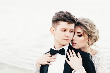 Wedding. The young cute couple walks and spends time at the local beach near the lake