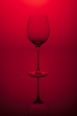 Wine glass on a red background.