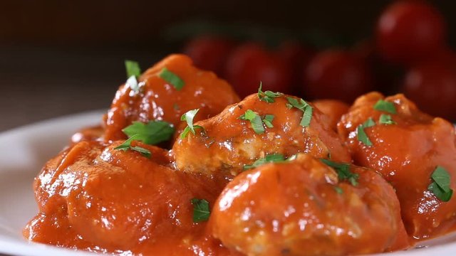 Spreading Fresh Chopped Parsley Over Meatballs With Tomato Sauce On The White Plate