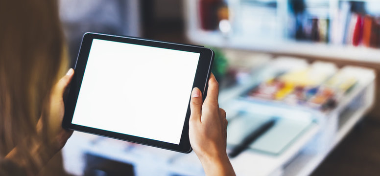 Hipster girl using tablet technology in home, blogger girl person holding computer with blank screen on background bokeh, female hands texting on relax holiday, mockup templates gadget